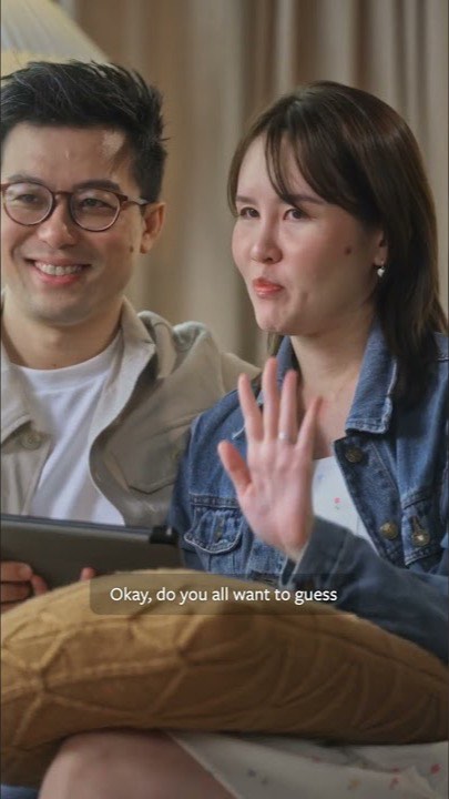A couple on a sofa, the woman waving at the camera, in Hello Love’s Heart-to-Heart Talk, episode 3